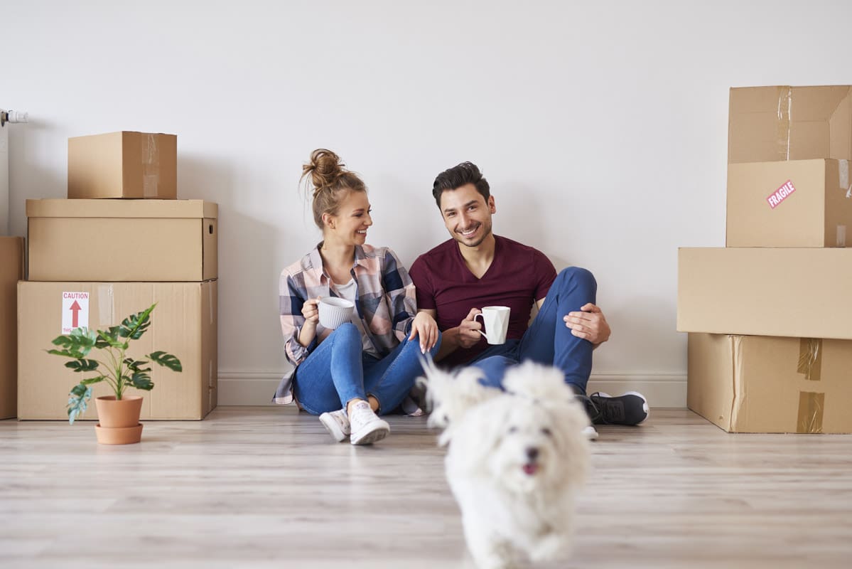 Man, woman, and their dog after moving in to a new home